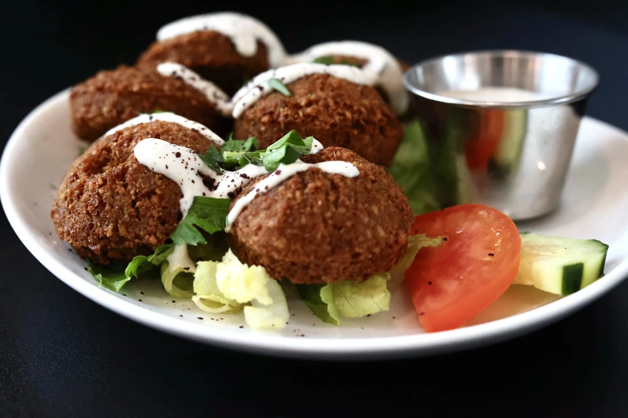 Falafel plate with garlic-yogurt tahini, fresh greens, tomato and cucumber at Leymoon Kitchen in Federal Way, WA