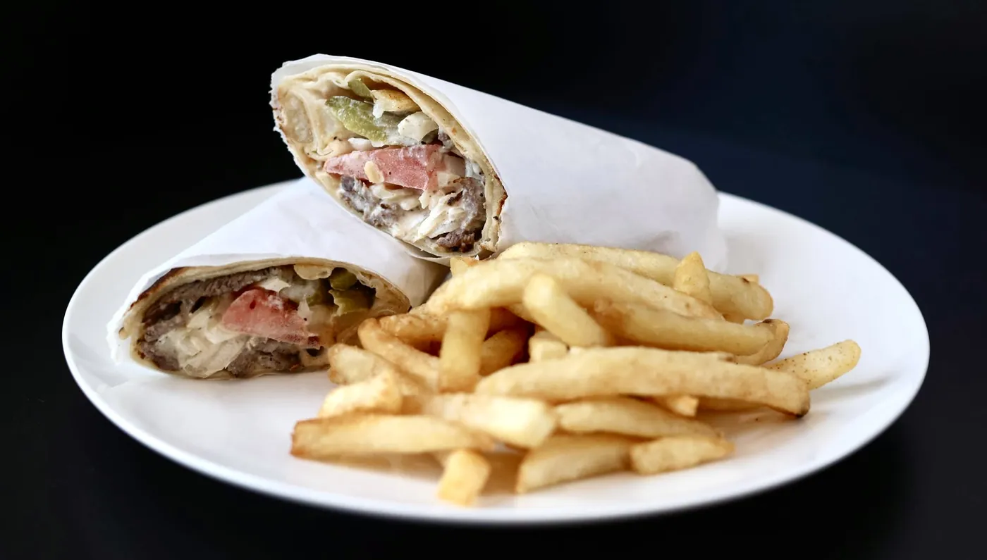 Shawarma wrap with pickles and garlic sauce, served with fries at Leymoon Kitchen